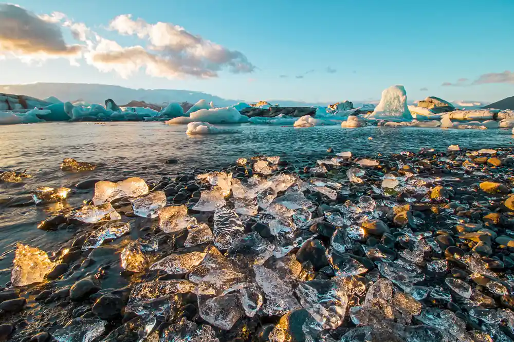 Black sand beach with turquoise icebergs and blue sky
