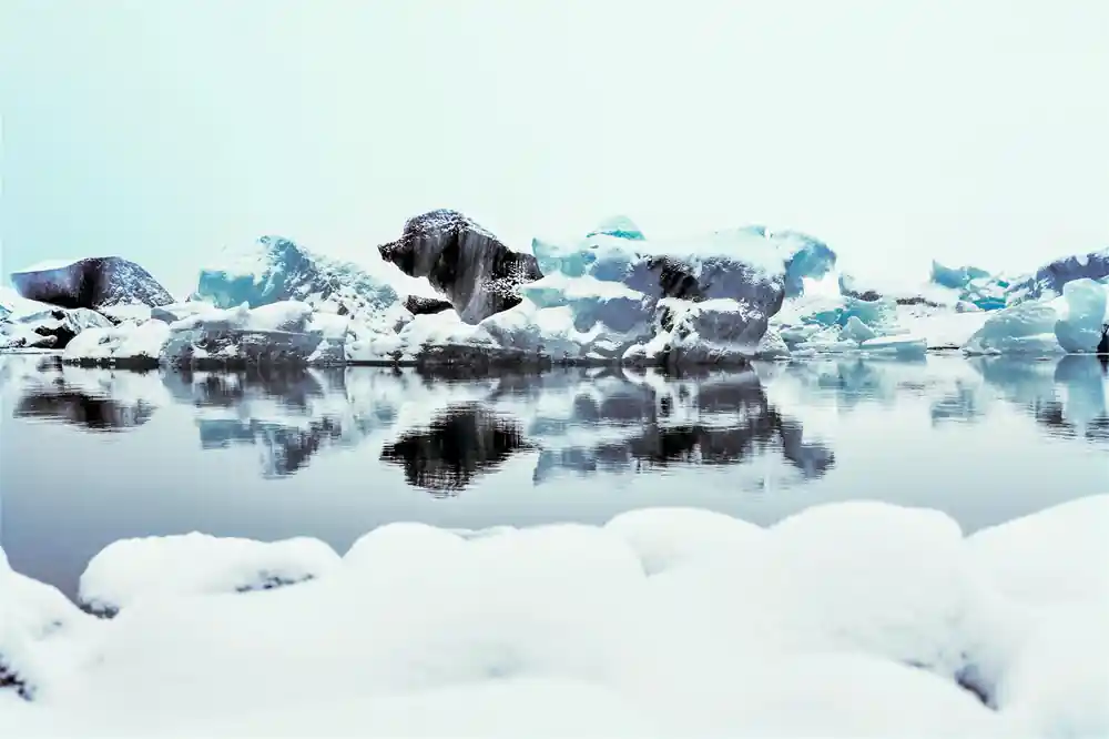 Icebergs reflected in calm glacial lake water