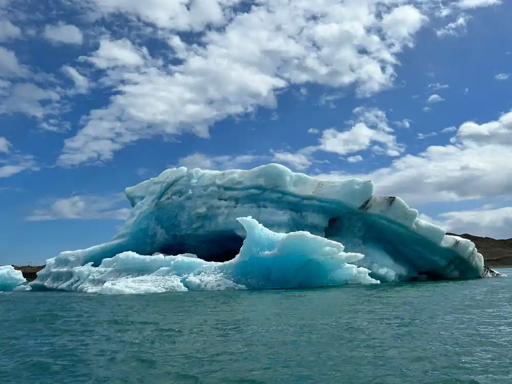 Large blue ice berg floating in glacial lake