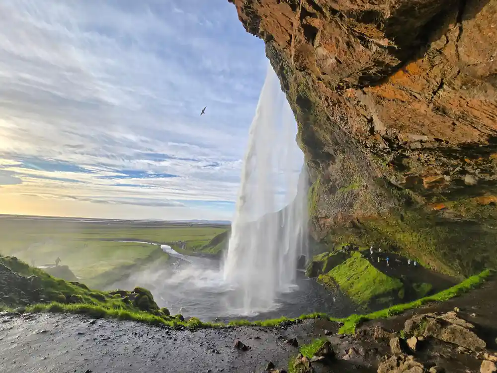 Waterfall flowing from cliff edge with green moss